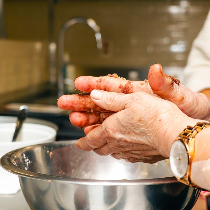 Mãos misturando ingredientes em uma tigela durante aula de gastronomia