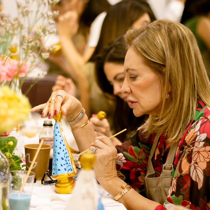 Participante pintando peça decorativa em workshop de pintura