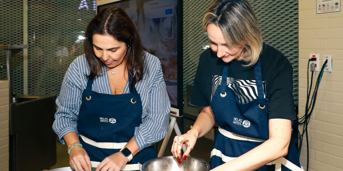 Participantes de avental preparando receita em aula de gastronomia